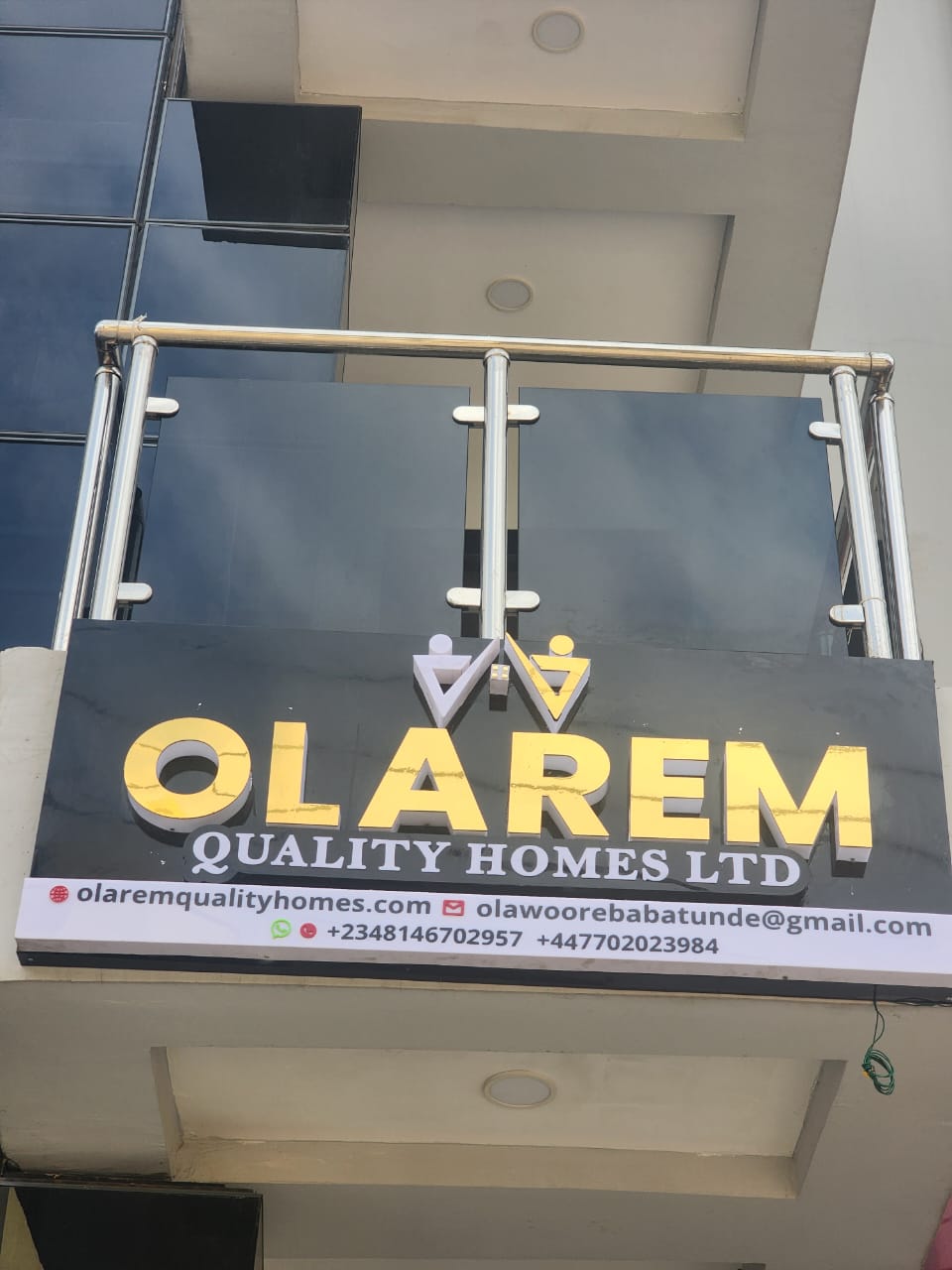 Gold marble-finish Olarem Quality Homes Ltd facade signage with contact bar