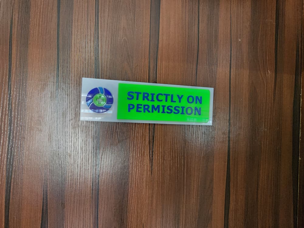 Acrylic Strictly on Permission door plaque with Trinity Pharmacare logo on a timber door