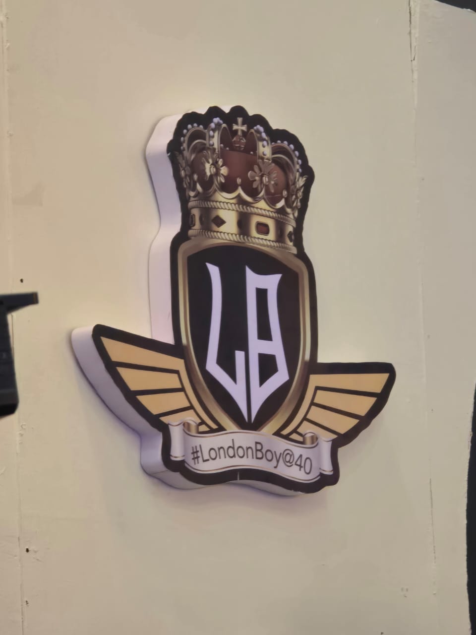 Illuminated #LondonBoy@40 crowned crest with winged shield signage