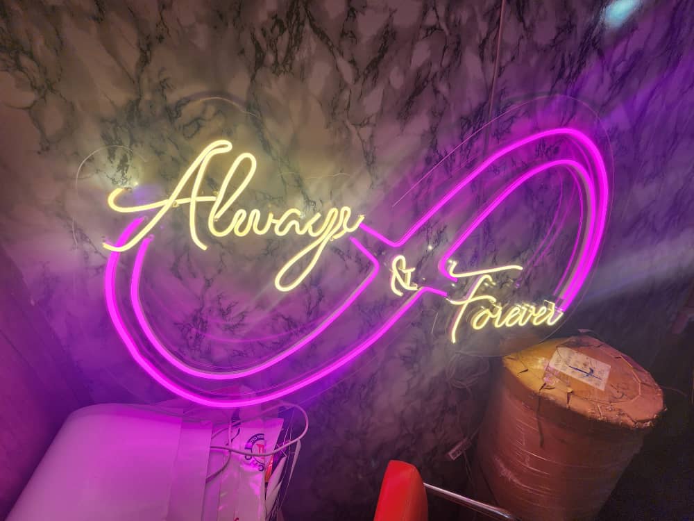 Pink and warm white Always and Forever infinity neon sign on marble wall