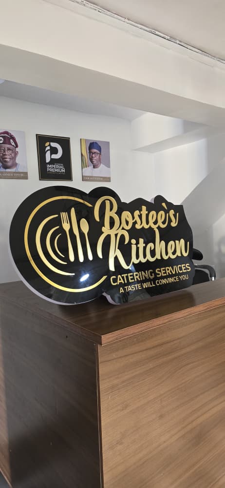 Black acrylic 3D logo signage with gold lettering for Bostee's Kitchen Catering Services