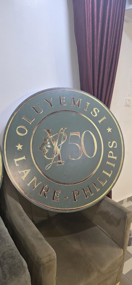 Hand-finished green and gold circular commemorative crest for Oluyemisi Lanre-Phillips at 50