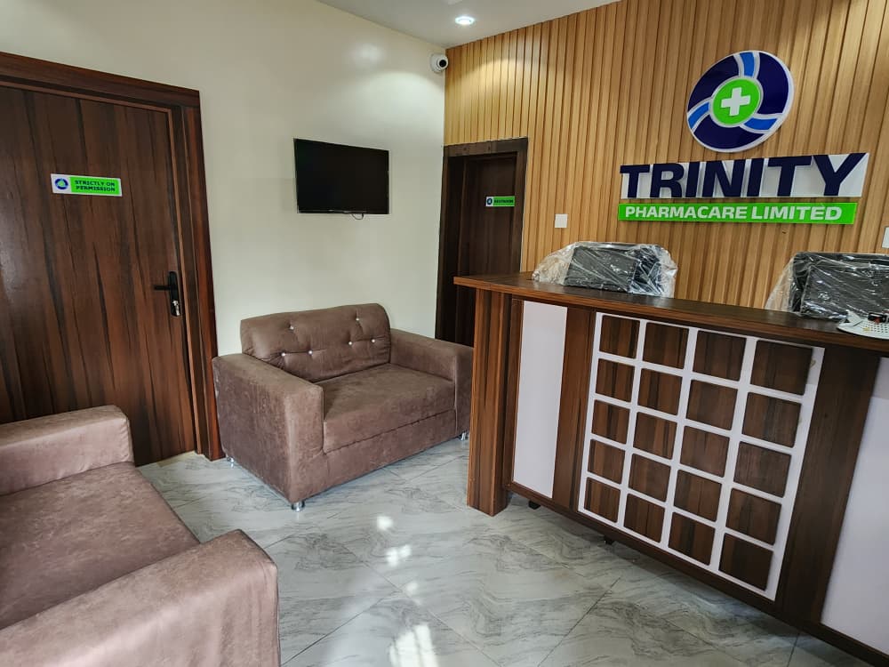 Trinity Pharmacare Limited 3D reception wall logo installed above a custom timber front desk