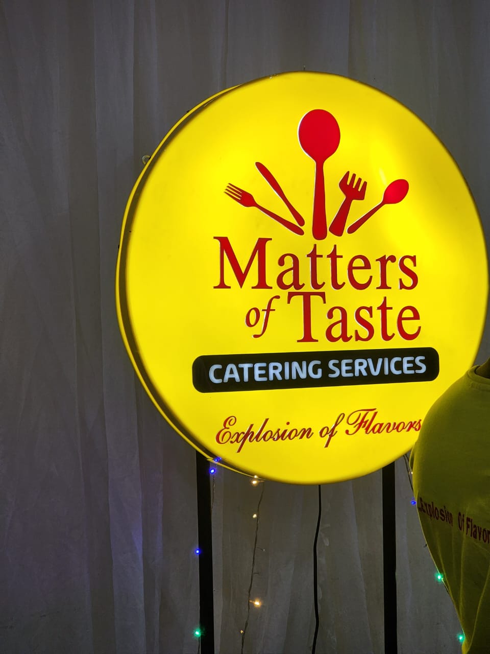 Backlit yellow roundel signage for Matters of Taste Catering Services — Explosion of Flavors