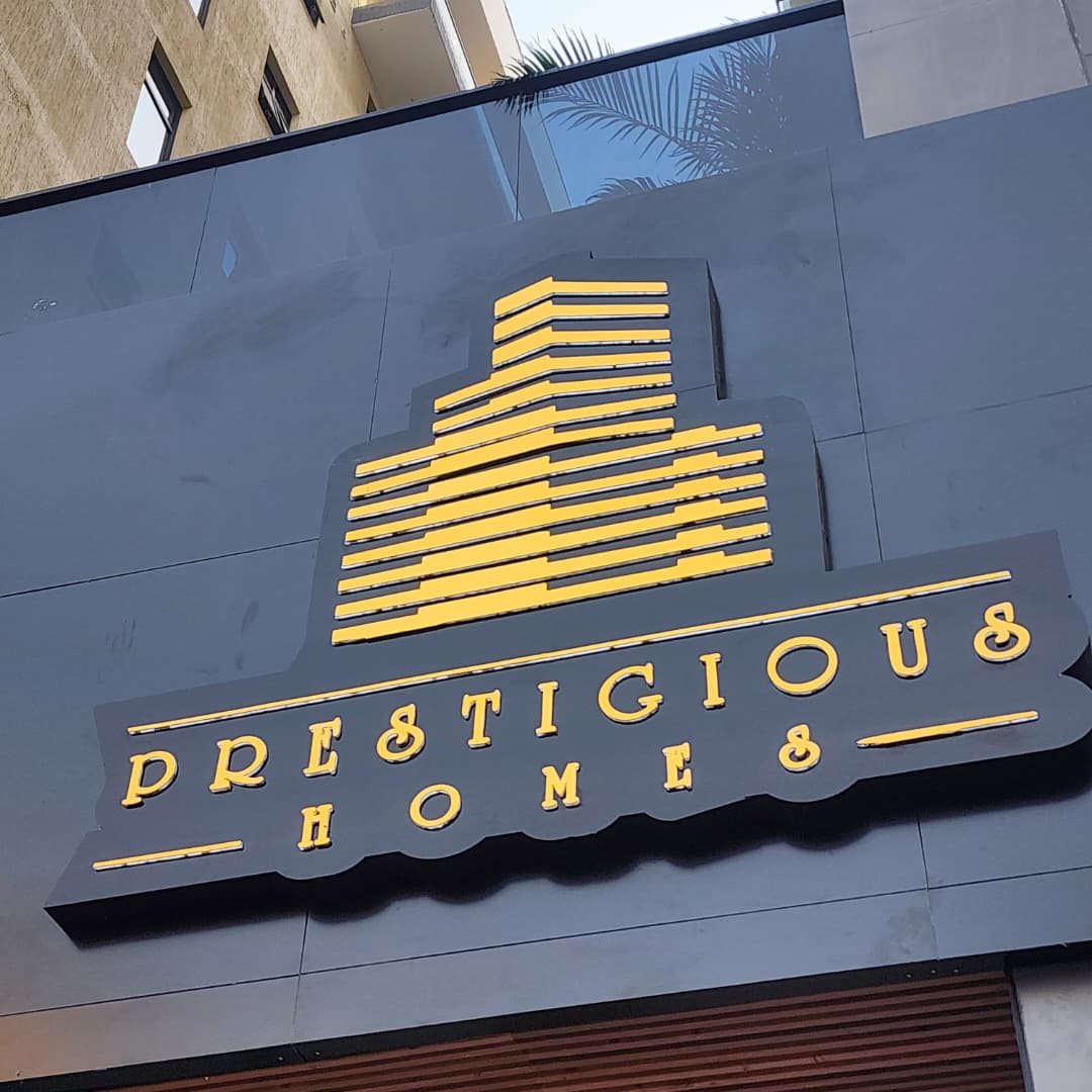 Art-deco style Prestigious Homes gold-on-charcoal facade signage with skyline motif