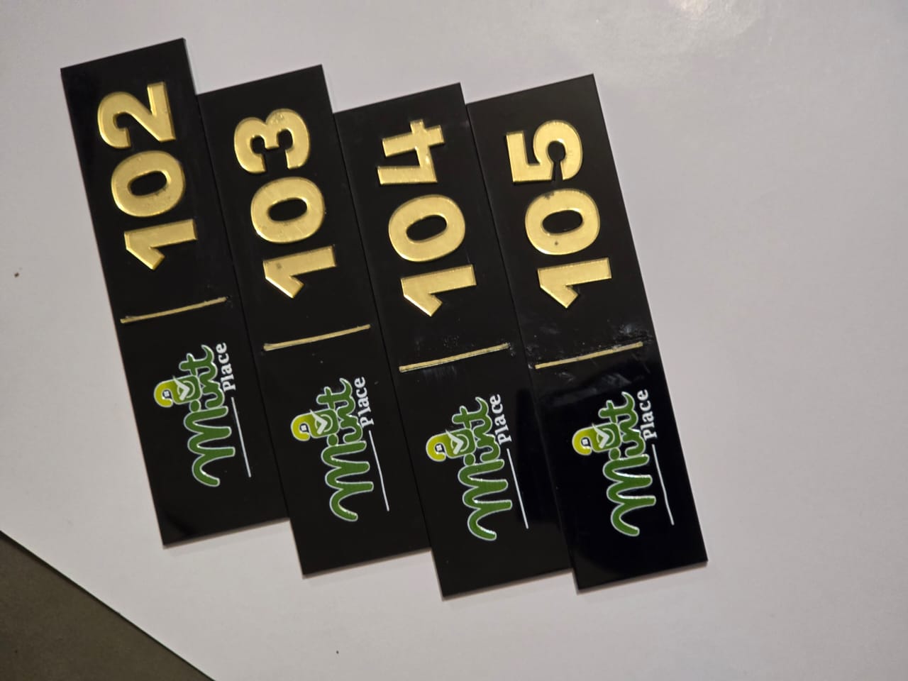 Set of black acrylic apartment door number plaques with gold 3D numerals for Mint Place