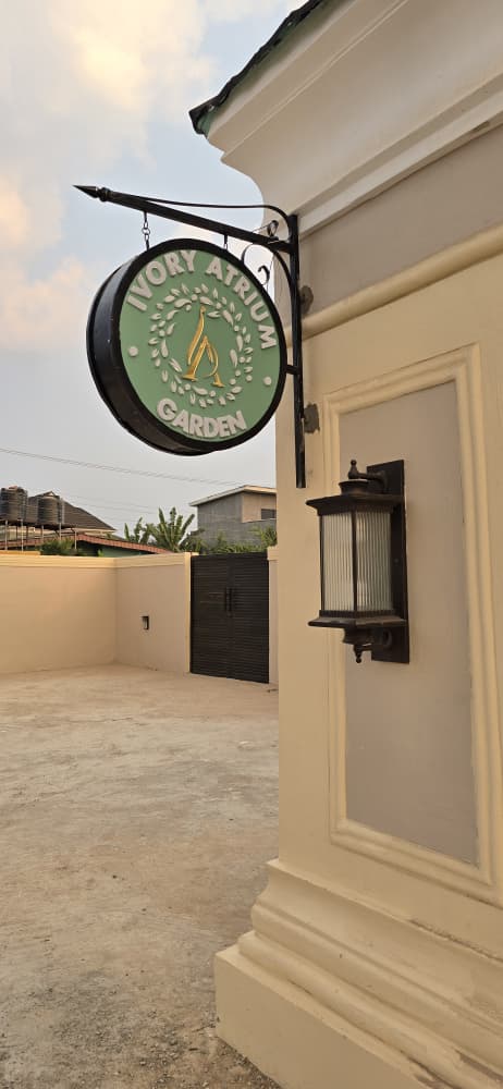 Double-sided round projecting sign with wrought-iron bracket for Ivory Atrium Garden