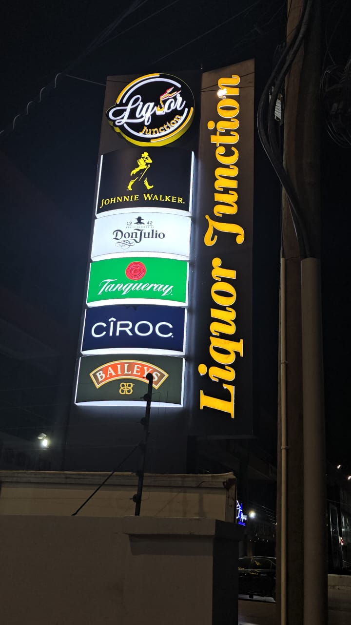 Tall illuminated tower signage for Liquor Junction featuring premium liquor brands